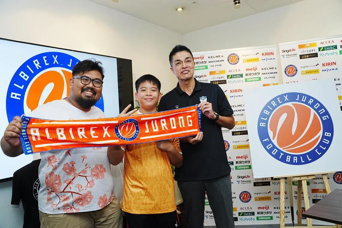 From right: Albirex Niigata chairman Daisuke Korenaga unveiling the club's new name Albirex Jurong and new emblem alongside fans Toby Jiang and Amir Hamizan.