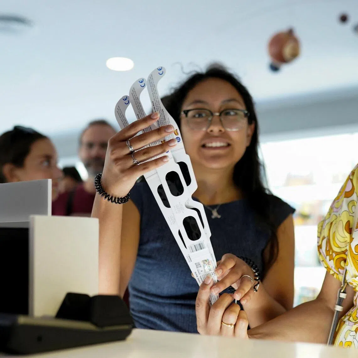 A lucky buyer manages to snag a pair of eclipse-viewing glasses at a store at Madrid’s planetarium.