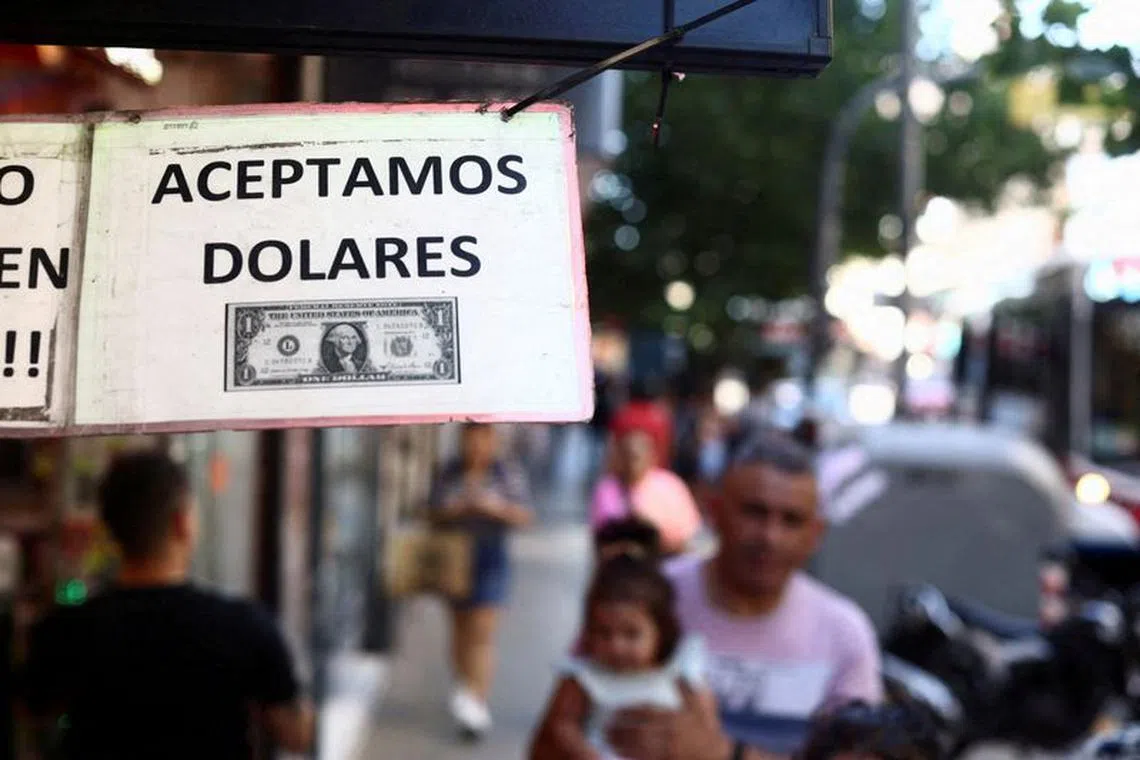 FILE PHOTO: A sign outside a store reads in Spanish \"We accept Dollars\" in Buenos Aires, Argentina, December 12, 2023. REUTERS/Tomas Cuesta/File Photo
