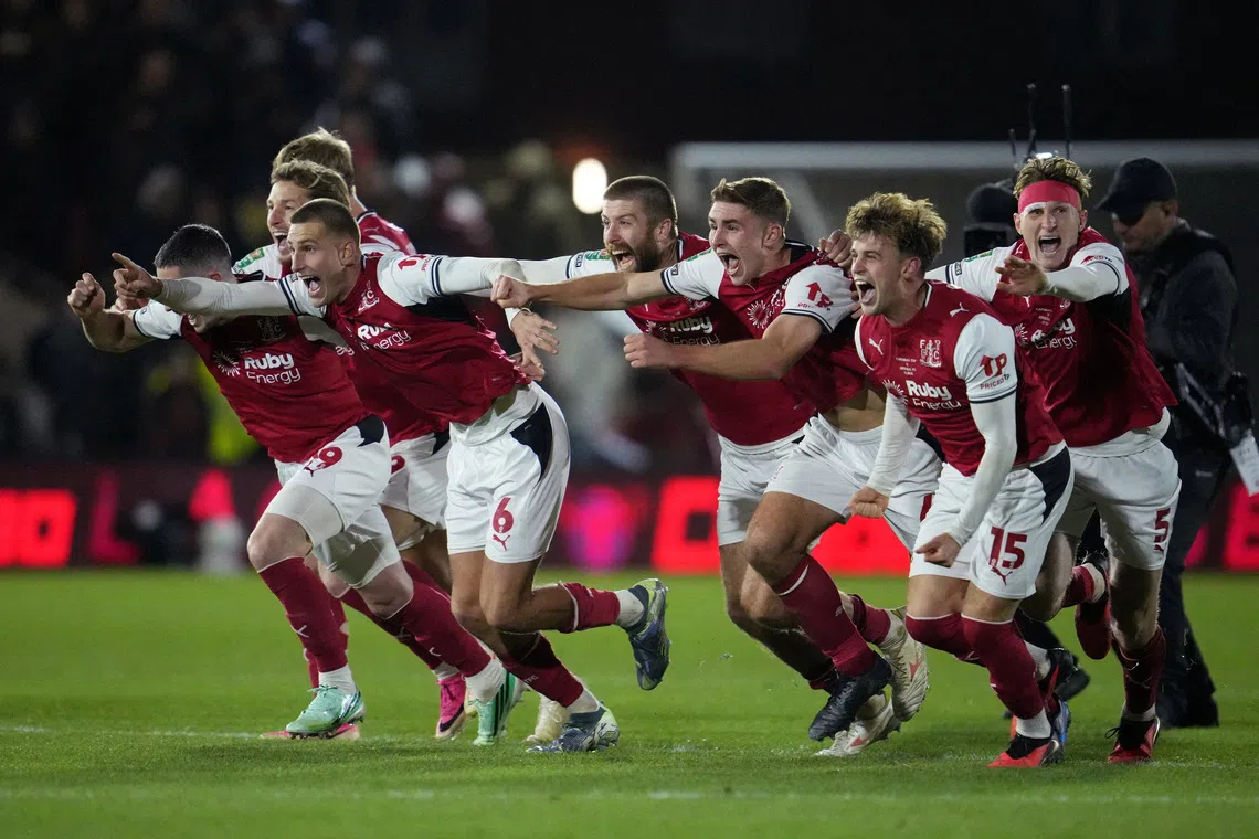 Fleetwood Town players celebrate beating Arsenal after a penalty shoot-out.