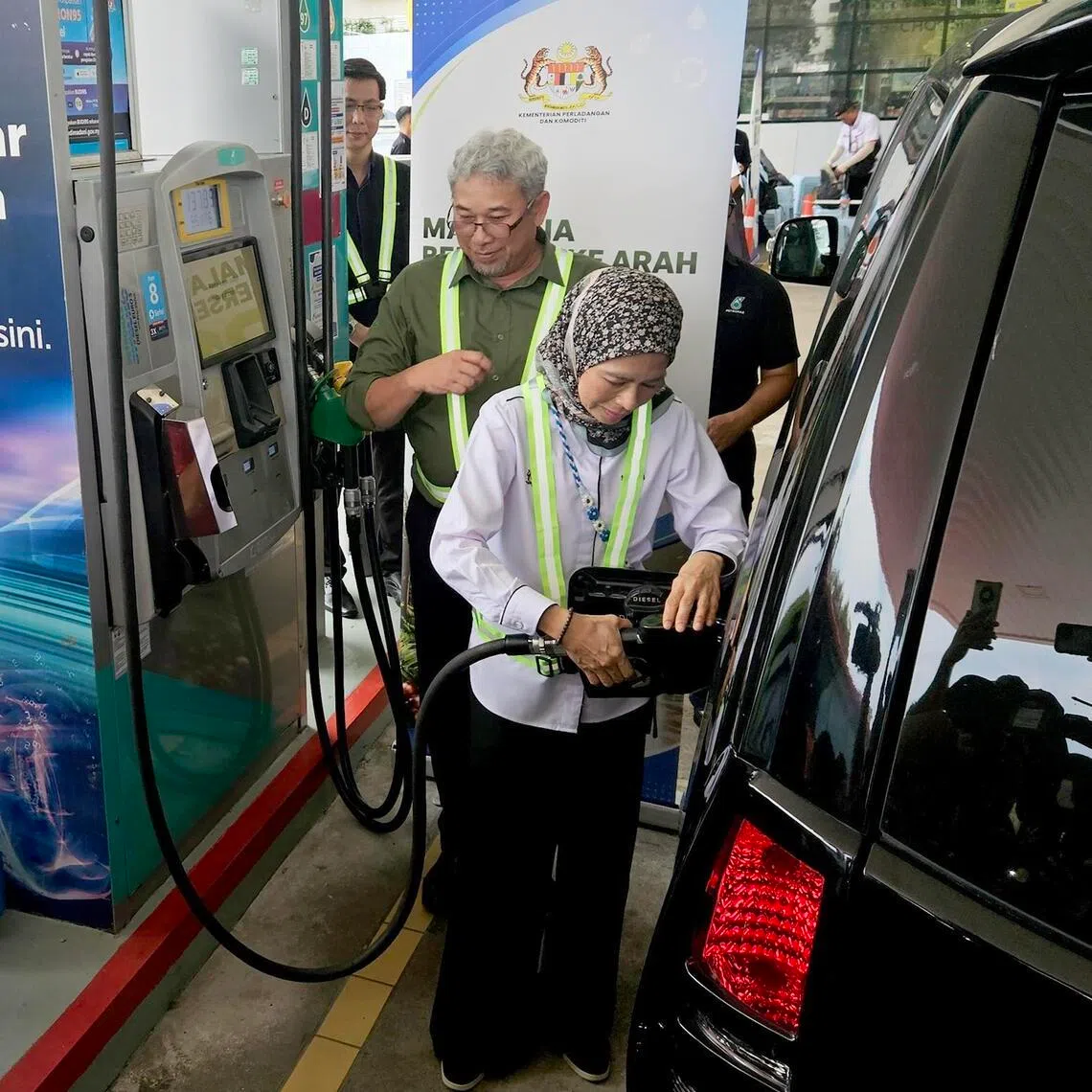 Plantation and Commodities Minister Noraini Ahmad is fueling a car with B15 biodiesel during the launch of the B15 biodiesel initiative on June 4.