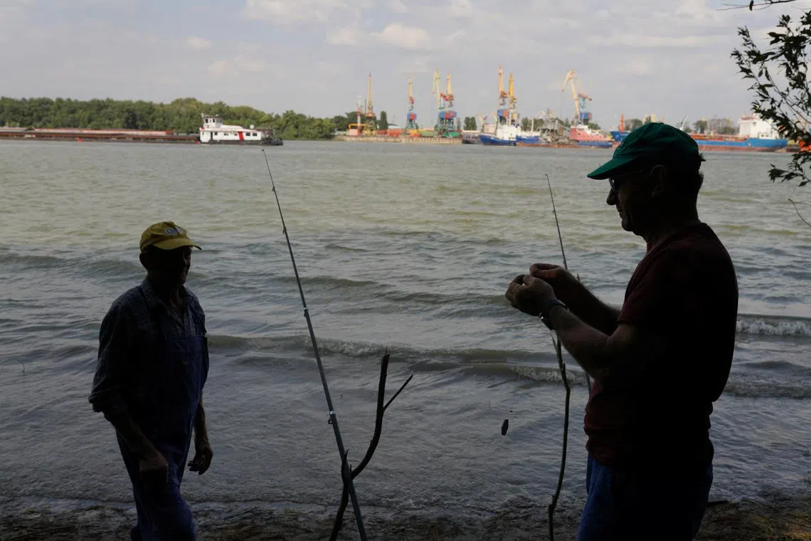 Two men prepare to fish across the Danube from the port of Izmail, in Plauru, Romania, September 5, 2023. REUTERS/Andreea Campeanu