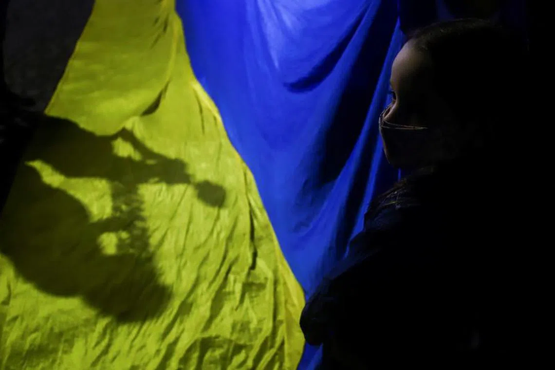 A girl holds a Ukraine's flag during a protest against the massive military operation by Russia against Ukraine, in front of the Ukrainian Embassy in Buenos Aires, Argentina February 24, 2022. REUTERS/Matias Baglietto/File Photo
