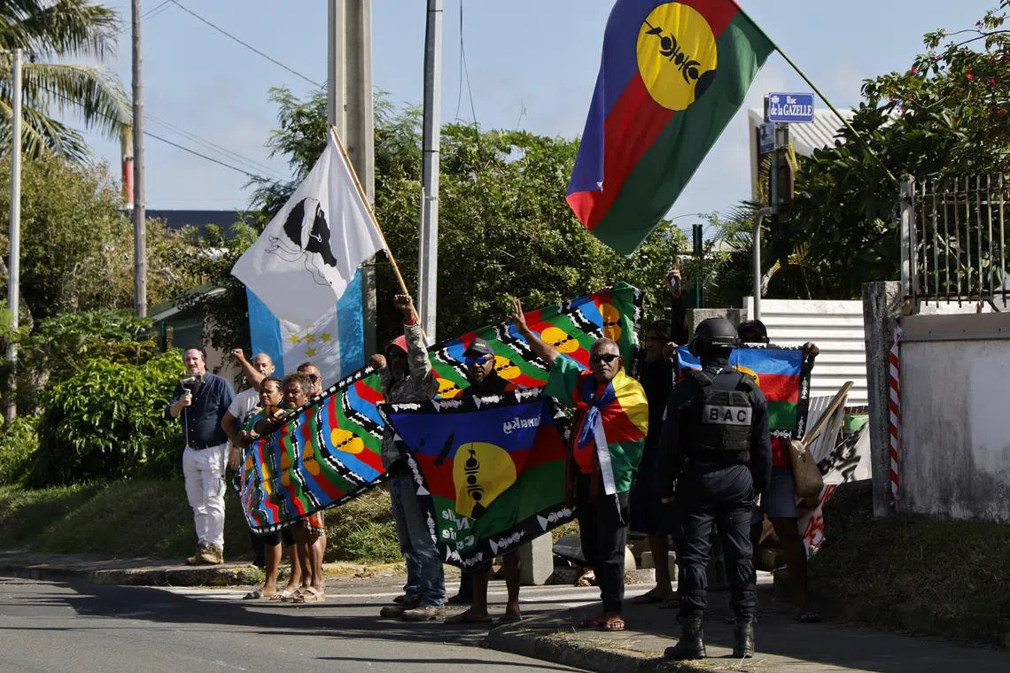 People demonstrate as French President Emmanuel Macron's motorcade drives past in Noumea, France's Pacific territory of New Caledonia on May 23, 2024. LUDOVIC MARIN/Pool via REUTERS/File Photo