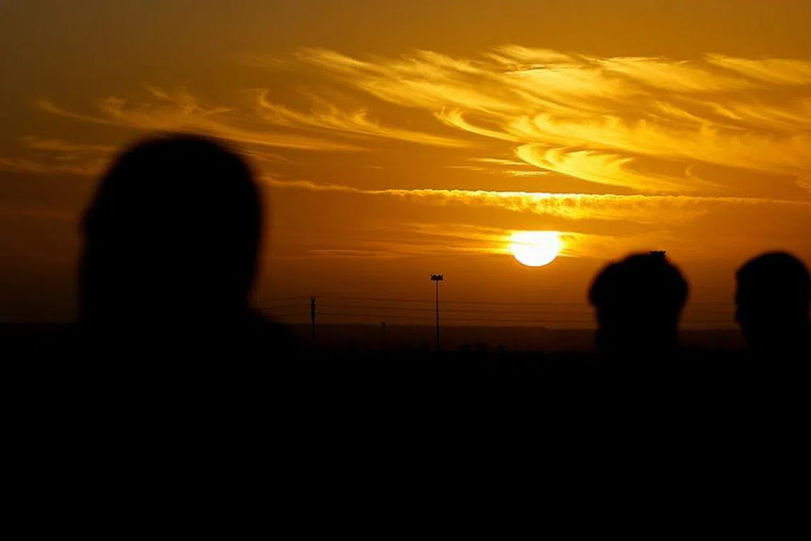 Sun sets as people gather at Rafah border as Hamas militants are expected to release hostages abducted by Hamas during the October 7 attack on Israel. REUTERS/Ibraheem Abu Mustafa/File Photo