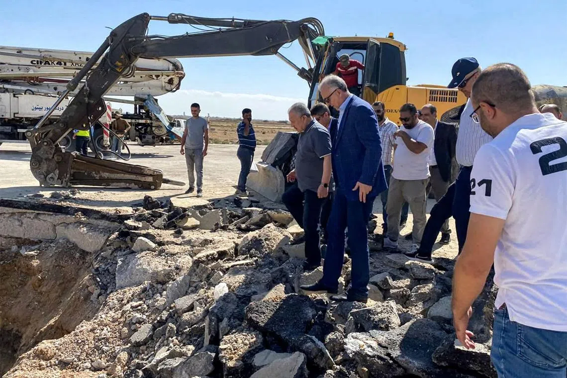 This handout picture released by the Telegram channel of the official Syrian Arab News Agency (SANA) shows Syria's Prime Minister Hussein Arnous inspects damage at the runway of Damascus International Airport on the outskirts of the Syrian capital on October 13, 2023 after an Israeli air strike. (Photo by SANA / AFP) / == RESTRICTED TO EDITORIAL USE - MANDATORY CREDIT "AFP PHOTO / HO / SANA" - NO MARKETING NO ADVERTISING CAMPAIGNS - DISTRIBUTED AS A SERVICE TO CLIENTS ==