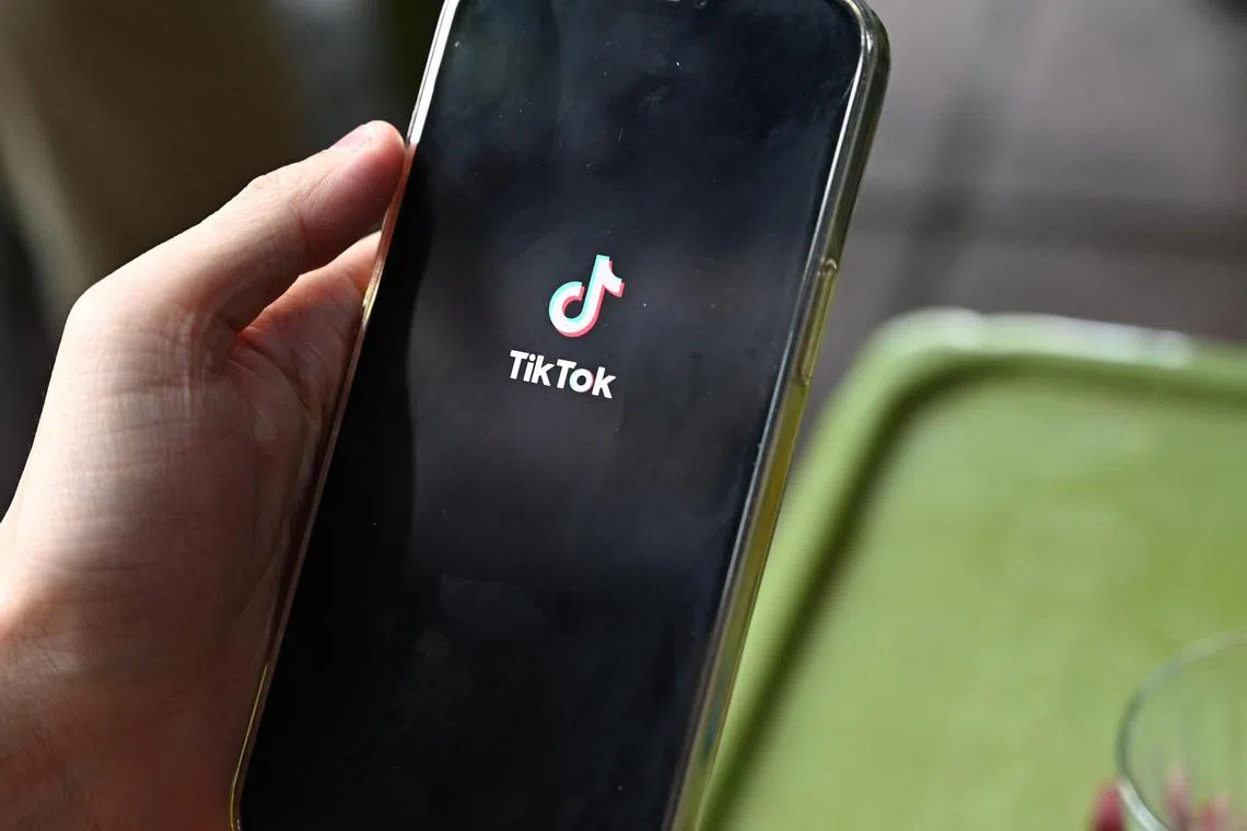 The logo of the social media platform TikTok is displayed on a mobile phone in Hanoi on October 6, 2023. Social media platforms operating in Vietnam including TikTok and Facebook removed nearly 800 posts containing "false or anti-state" information over the course of a month, state media said October 6, citing government figures. (Photo by Nhac NGUYEN / AFP)