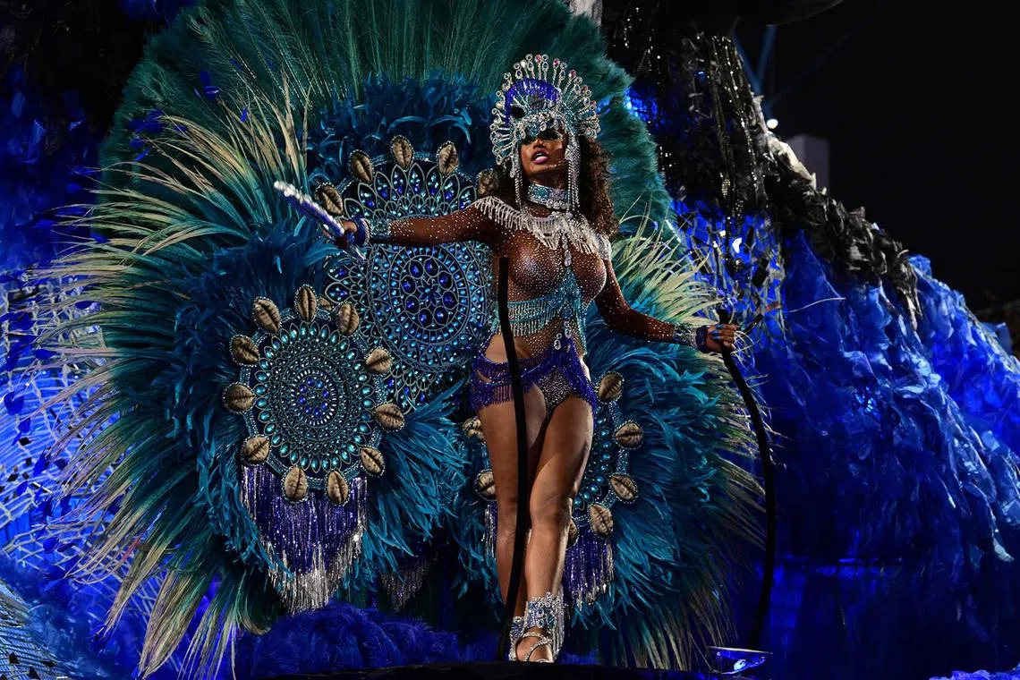 TOPSHOT - Members of Portela samba school perform during the last night of the Carnival parade at the Marques de Sapucai Sambadrome in Rio de Janeiro, Brazil, on February 12, 2024. (Photo by Pablo PORCIUNCULA / AFP)