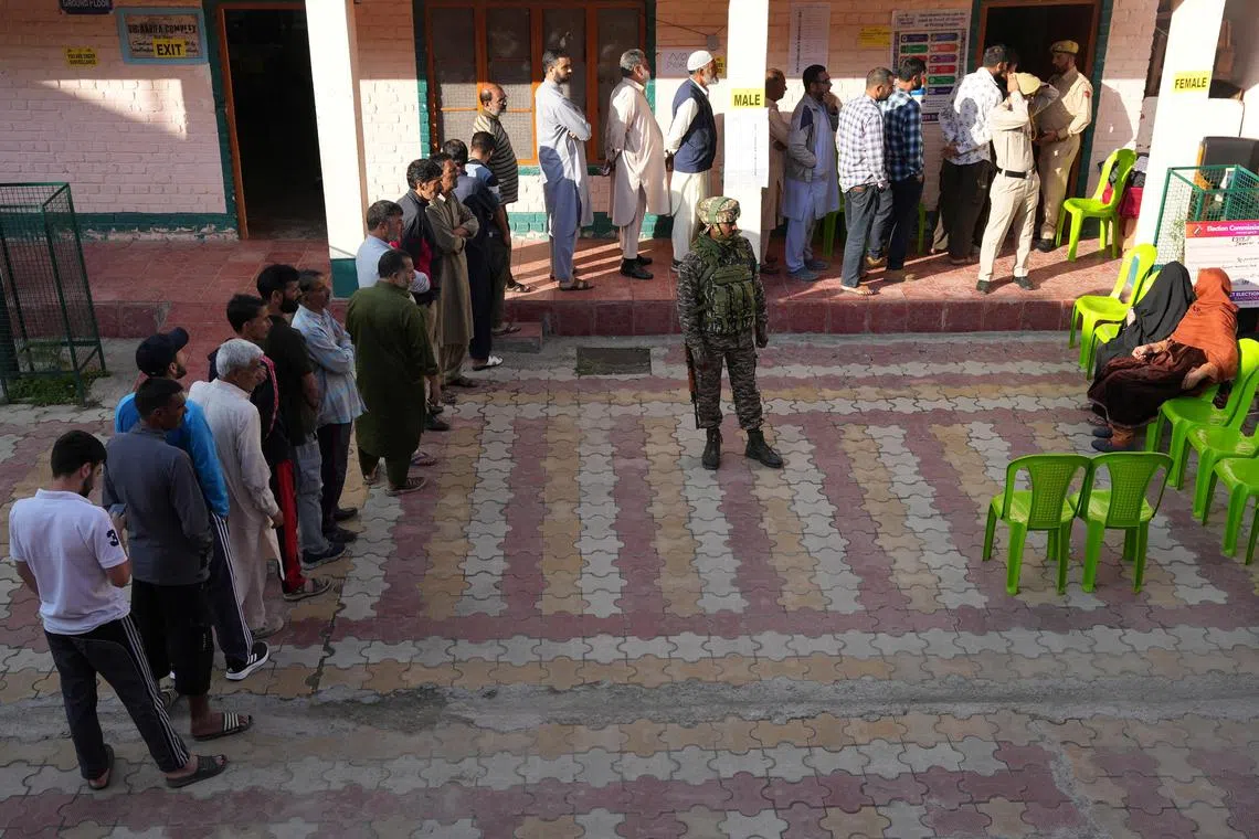 People waiting in a line to vote outside a polling station, during the third and final phase of the assembly election, in north Kashmir's Bandipora district on Oct 1. 