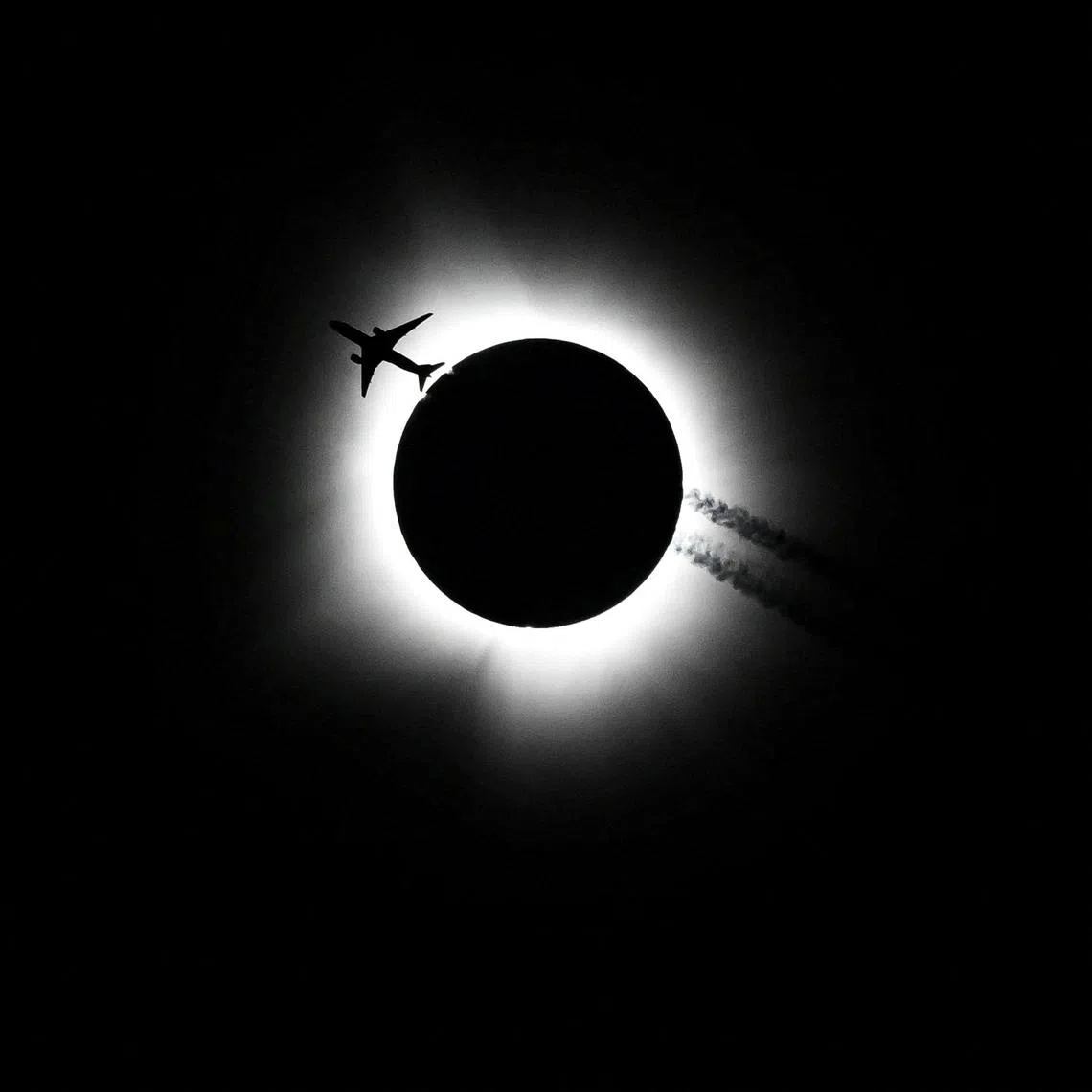An airplane passing near the total solar eclipse during the Hoosier Cosmic Celebration at Memorial Stadium in Bloomington, Indiana, on April 8, 2024. 
