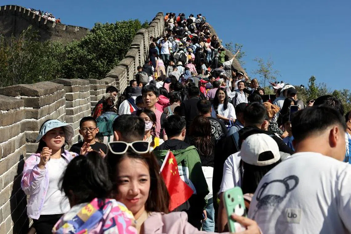FILE PHOTO: A woman poses for pictures amid tourists visiting the Badaling section of the Great Wall on the National Day holiday in Beijing, China October 1, 2023. REUTERS/Florence Lo/File Photo