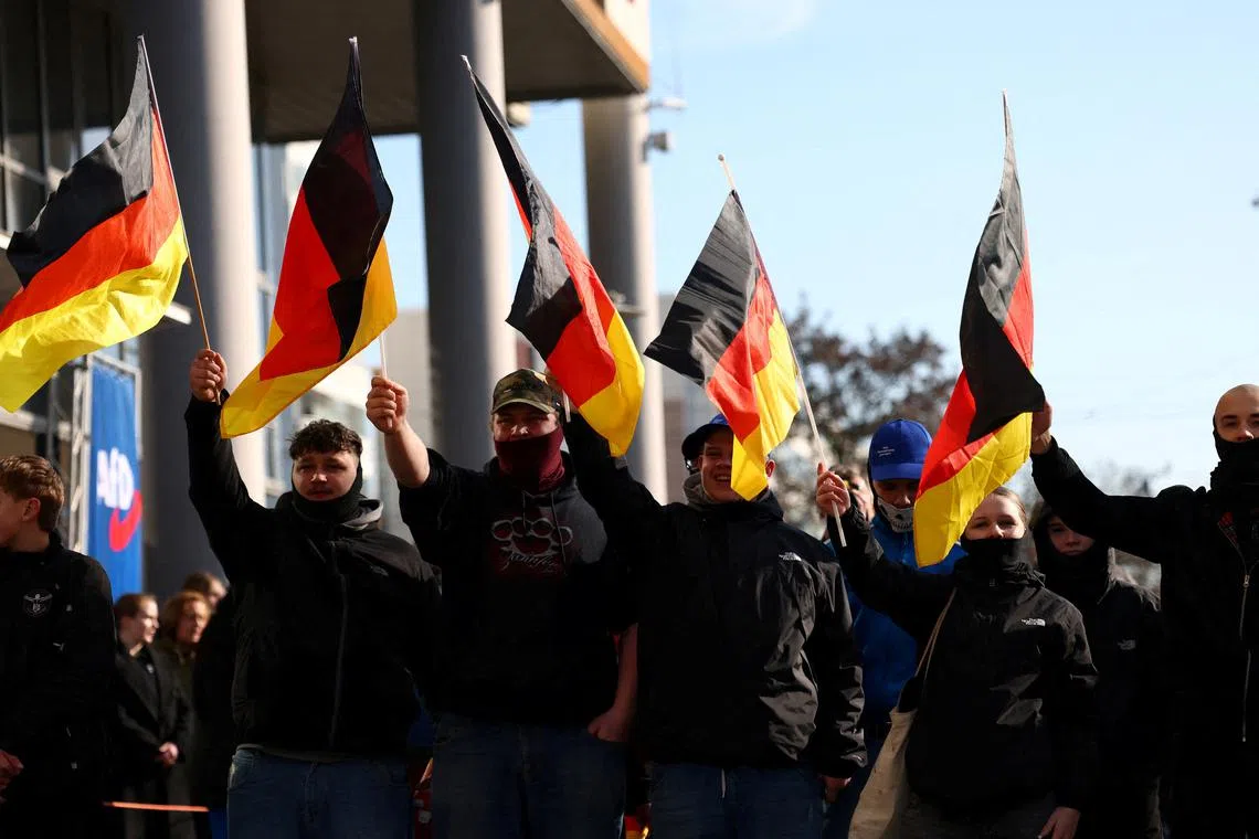 FILE PHOTO: Supporters of the Alternative for Germany party (AfD) wave flags as they take part in an AfD campaign rally in Hohenschoenhausen, Berlin, Germany, February 22, 2025. REUTERS/Christian Mang/File Photo