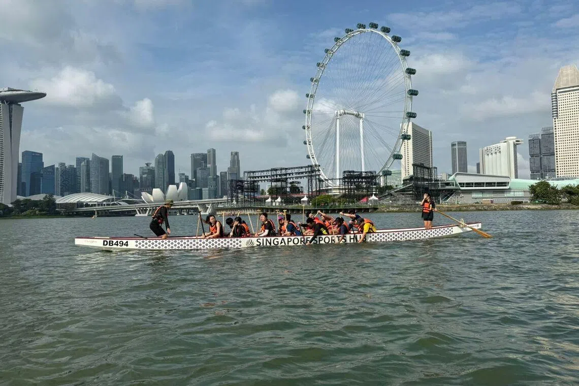 EY Singapore’s dragon boating team practicing against the Singapore skyline of MBS Financial Centre