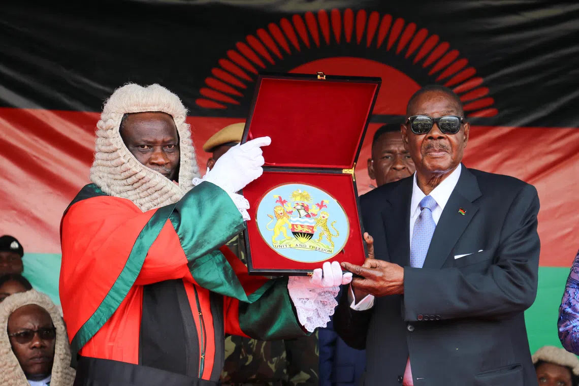 Arthur Peter Mutharika, the newly elected seventh president of Malawi, holds a Bible as he takes oath of office from the Chief Justice of the Malawi Supreme Court, Justice Rezine Mzikamanda shortly after his inauguration at the Kamuzu stadium in Blantyre, Malawi, October 4, 2025.  REUTERS/Eldson Chagara