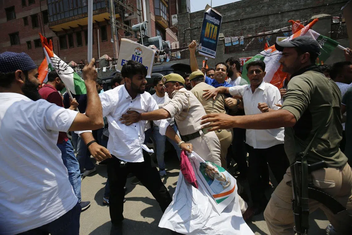 epa11438445 Members of the youth wing of the Indian National Congress party shout slogans as Indian police officers try to stop them during a protest in Srinagar, Kashmir, India, 26 June 2024. Members of the Youth Congress protested against the alleged government irregularities, paper leaks, and a sharp rise in the merit list of a prestigious exam. This unprecedented event saw 67 students scoring a perfect 720, marking a historic occurrence in the National Testing Agency's (NTA) history.  EPA-EFE/FAROOQ KHAN