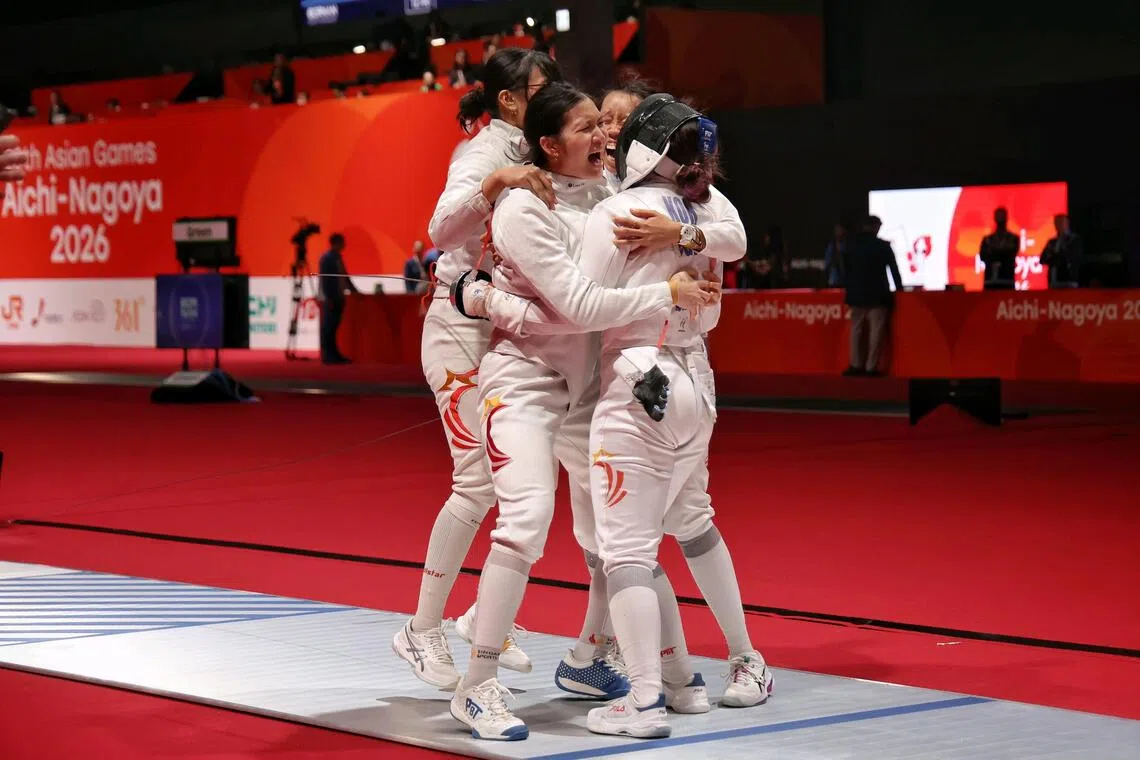 Singapore’s Elle Koh (right) getting mobbed by her teammates after securing a 42-41 win over Uzbekistan in the women’s epee team quarter-finals at the Asian Games on Sept 25, which helped them win a bronze medal.