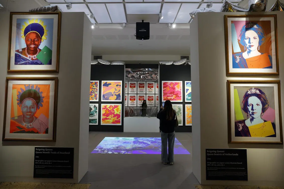 Visitors examine artworks by US artist Andy Warhol - including two portraits of former Dutch queen Beatrix (right) - at an exhibition at the La Banque Museum in Hyeres, southern France, on April 16. 