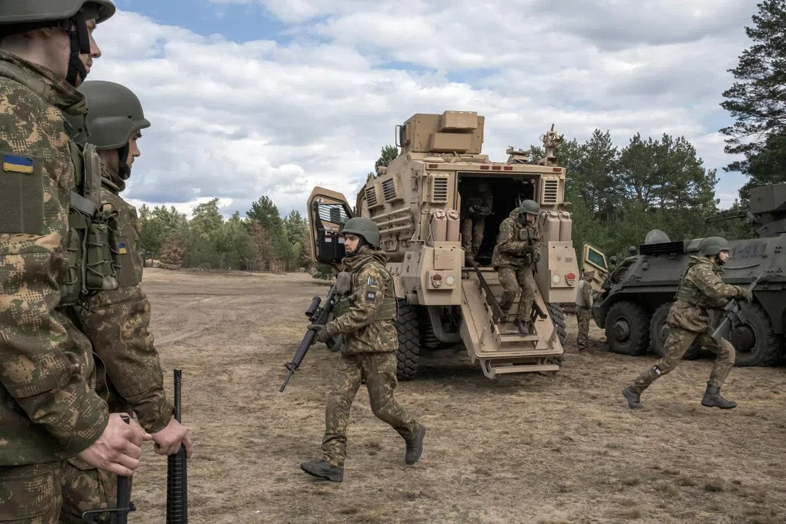 Azov regiment recruits disembark from an American tactical vehicle during training near Kyiv.
