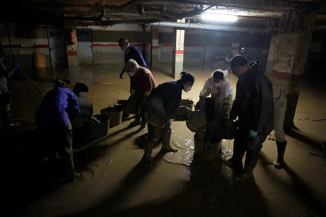 FILE PHOTO: Volunteers remove floodwaters from a community garage, following the deadly October 29 floods in Paiporta, Valencia, Spain, November 16, 2024. REUTERS/Vincent West/File Photo