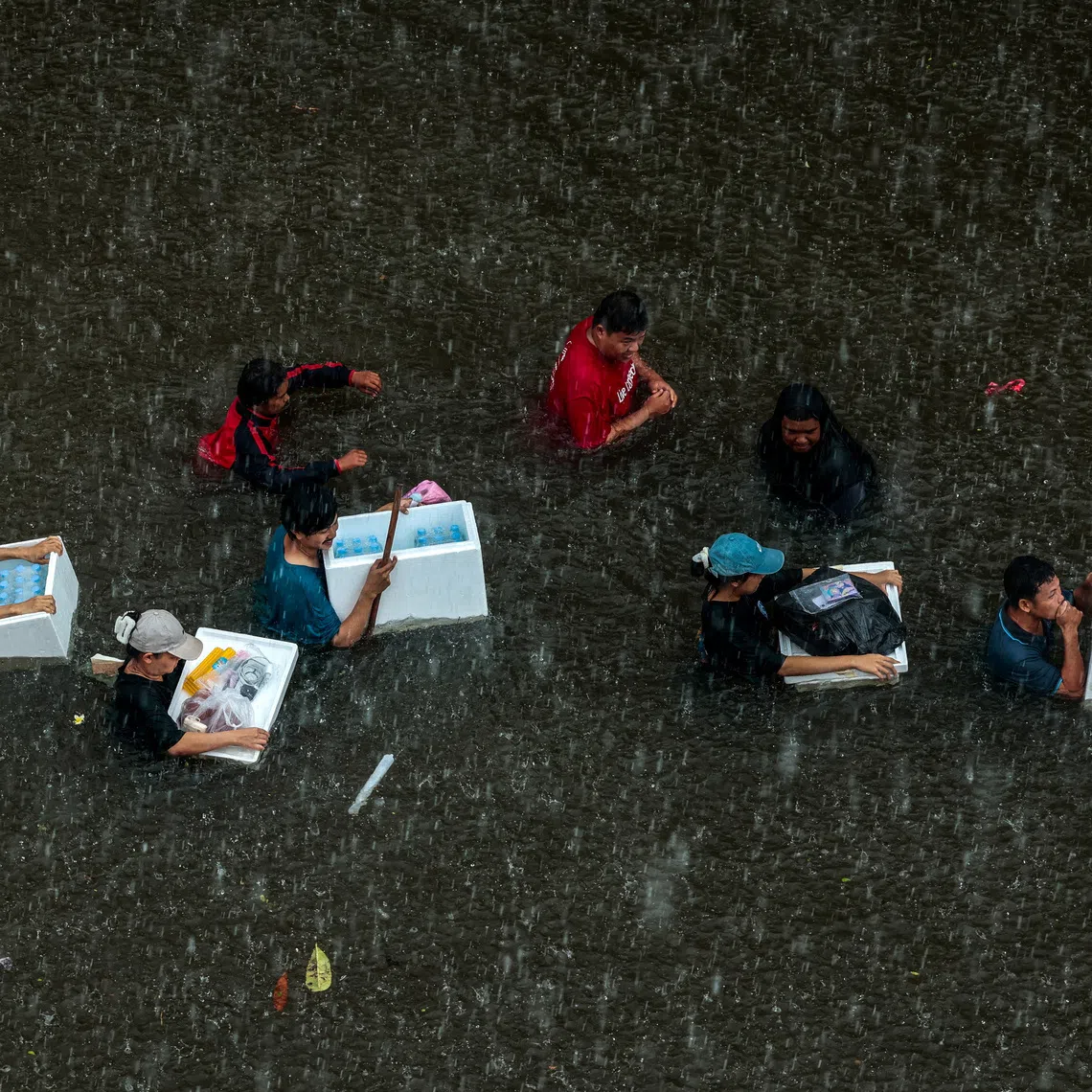 People wade through a flooded area during heavy rain in Bangkok, Thailand, September 27, 2026. REUTERS/Patipat Janthong