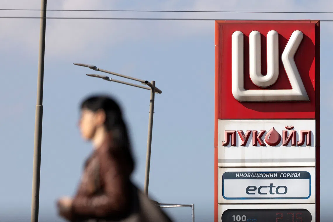 A woman walks near a Lukoil gas station in Sofia, Bulgaria, October 23, 2025.  REUTERS/Stoyan Nenov