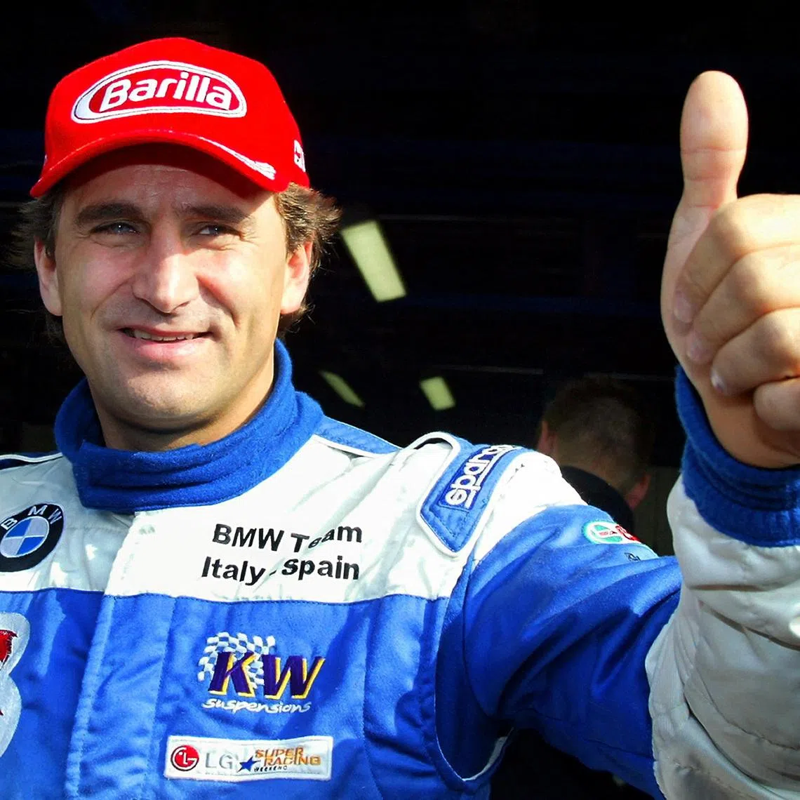 FILE PHOTO: Italian BMW 320i racing car driver Alex Zanardi gives a thumbs up before the start of an LG Super Racing car event at the Monza race track October 19, 2003. REUTERS/Giampiero Sposito  GS/File Photo