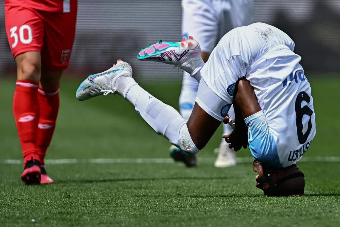 Napoli's Nigerian forward Victor Osimhen falling on the head during the Italian Serie A football match between Monza and Napoli on May 14, at the Brianteo stadium in Monza. 