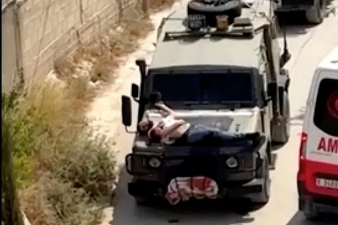 A Palestinian man is strapped on a military jeep during a raid in Jenin, the West Bank, in this screengrab from a video on June 22. 