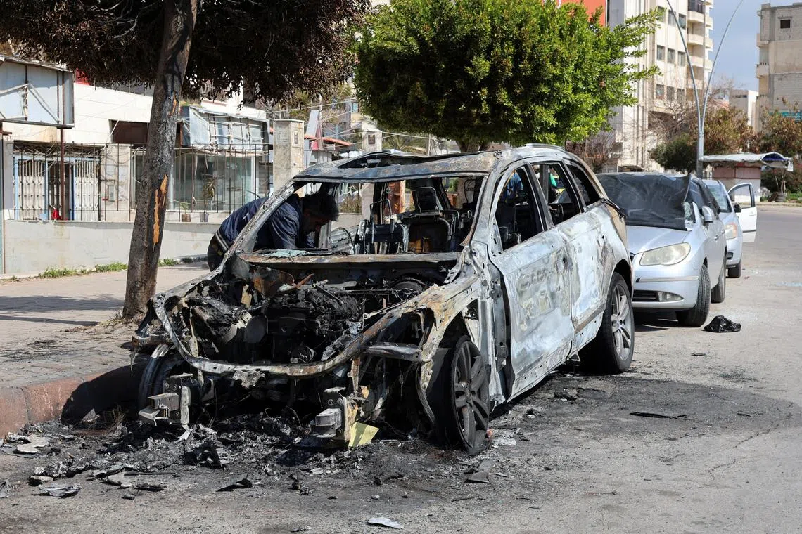 FILE PHOTO: A man inspects a damaged car in Latakia, after hundreds were reportedly killed in some of the deadliest violence in 13 years of civil war, pitting loyalists of deposed President Bashar al-Assad against the country's new Islamist rulers, Syria March 9, 2025. REUTERS/Haidar Mustafa/File photo