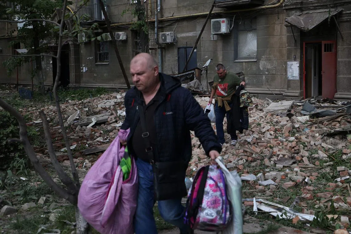 Local residents fleeing an apartment building in Ukraine's Dnipro after a Russian missile attack, in April 2024.