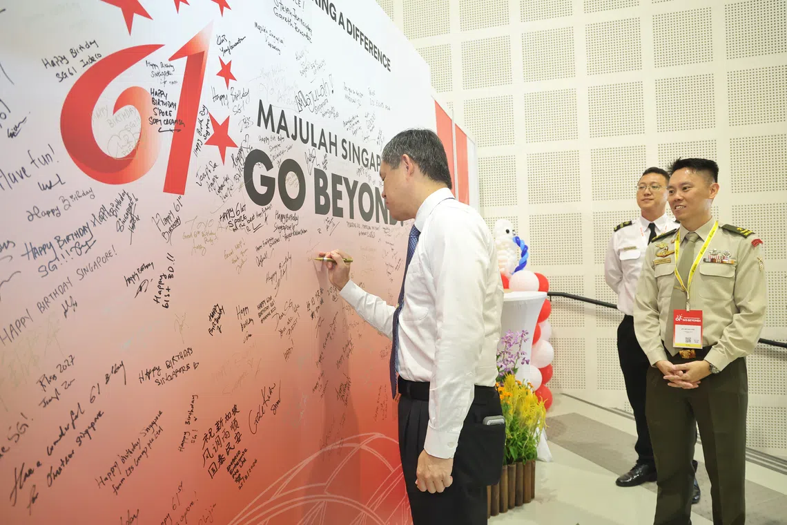 Defence Minister Chan Chun Sing signing the Signature Wall at the NDP 2026 appreciation function.