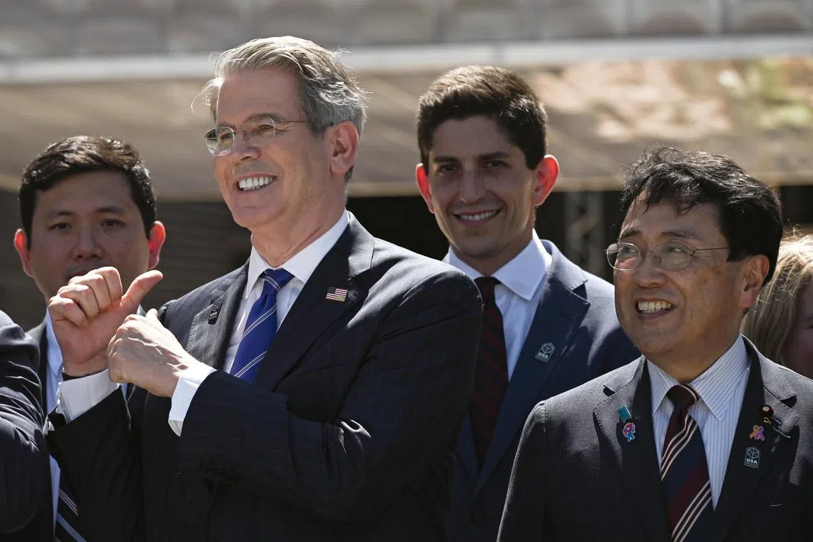 US Treasury Secretary Scott Bessent (second from left) gestures as he stands with Japan's Economic Revitalization Minister and chief trade negotiator Ryosei Akazawa (right) in front of the USA Pavilion for a photo session in Osaka on July 19. 
