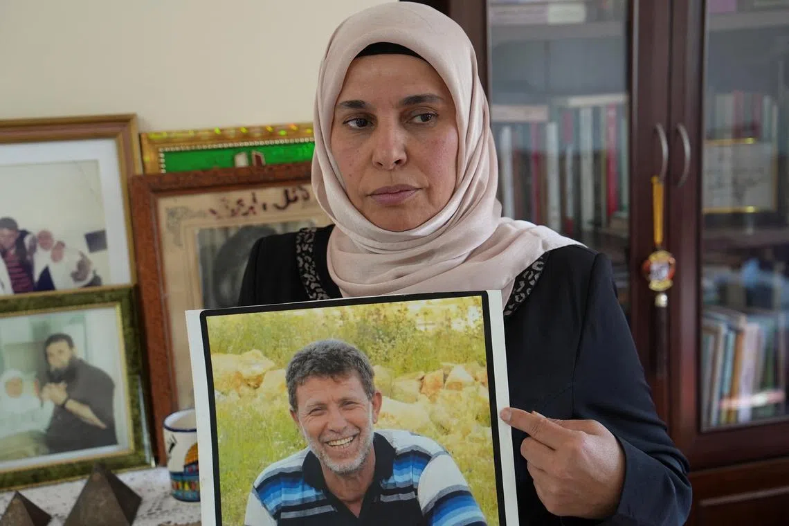 FILE PHOTO: Eman Nafe, the wife of Palestinian prisoner Nael Barghouti, who has spent 44 years in an Israeli jail, holds a picture of her husband, in her house near Ramallah, in the Israeli-occupied West Bank, January 18, 2025. REUTERS/Ismael Khader/File Photo