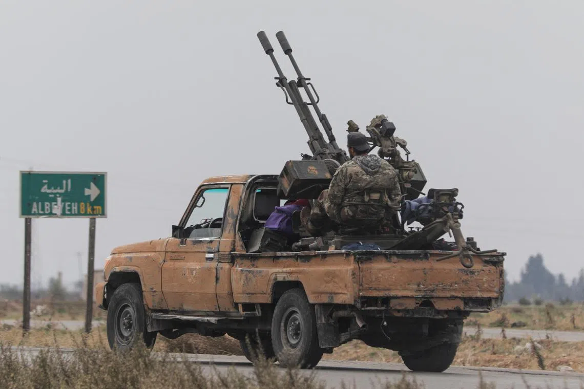 A rebel fighter sitting on the back of a vehicle in the countryside around Homs, after Syrian rebels pressed their lightning advance towards Damascus on Dec 7.
