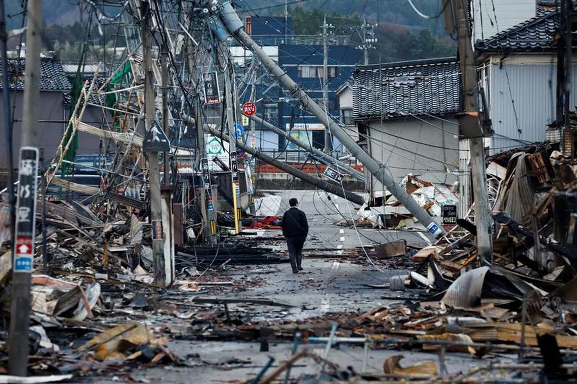 A man makes his way along Asaichi-dori street, which burned down due to a fire following an earthquake, in Wajima, Japan, January 4, 2024. REUTERS/Kim Kyung-Hoon