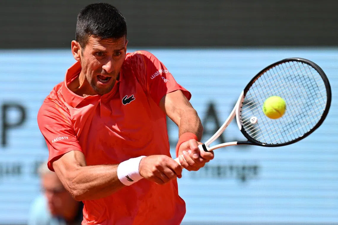 Novak Djokovic plays a backhand return to Juan Pablo Varillas during their French Open fourth-round clash.