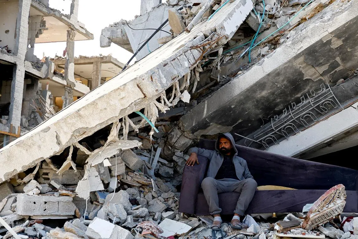 FILE PHOTO: A Palestinian man sits amidst the rubble of buildings destroyed during the Israeli offensive, amid a ceasefire between Israel and Hamas, in Rafah in the southern Gaza Strip February 16, 2025. REUTERS/Hatem Khaled/File Photo