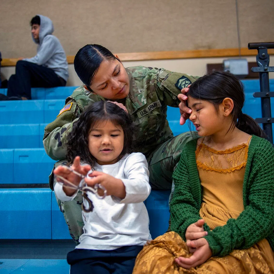 First Sergeant Rosa Cortez with two of her children, Celestina Rodriguez (left), 4, and Carmelena Rodriguez, 7, at a soccer game in which her son was playing, in The Dalles, Oregon, on Dec 6, 2025.
