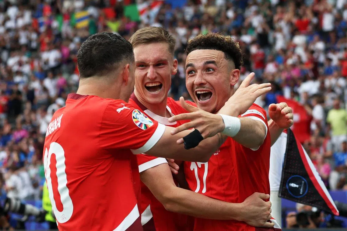 Midfielder Ruben Vargas (right) celebrates with teammates after scoring Switzerland's second goal.