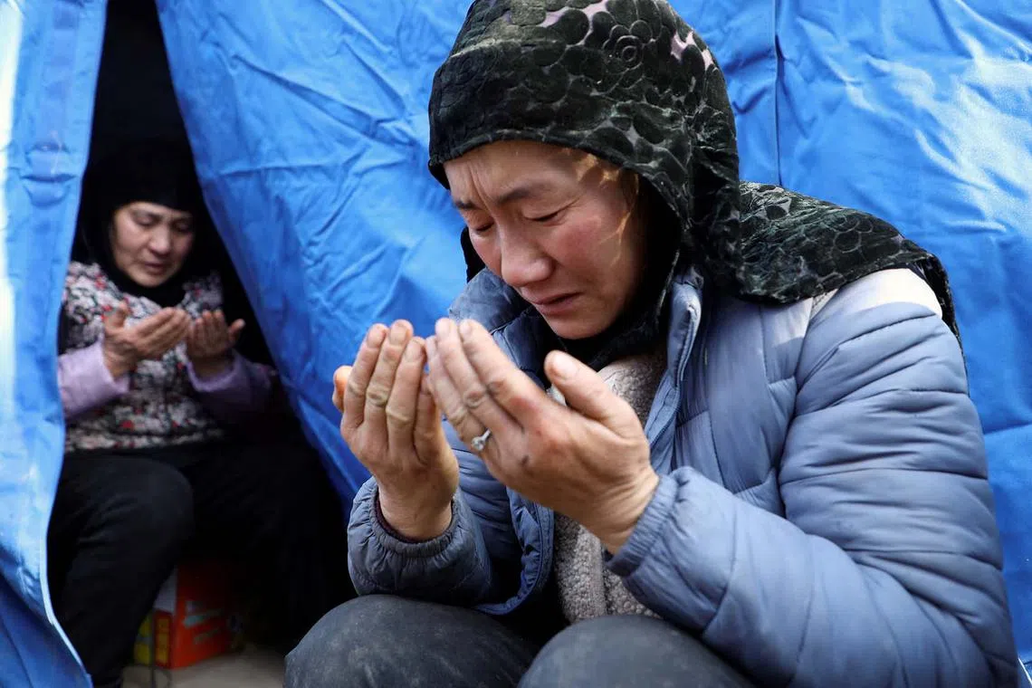 Women praying for Ma Jinyuan, an 8-year-old girl who passed away, at a temporary shelter at Yangwa village following the earthquake in Jishishan county, Gansu province, China, Dec 21, 2023. 