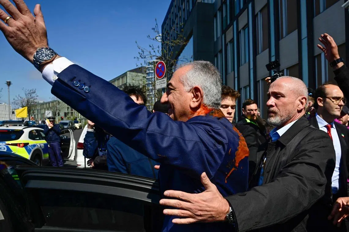 Mr Reza Pahlavi, the exiled son of Iran's last shah, was approached from behind by an unidentified man who splashed him with a red liquid.