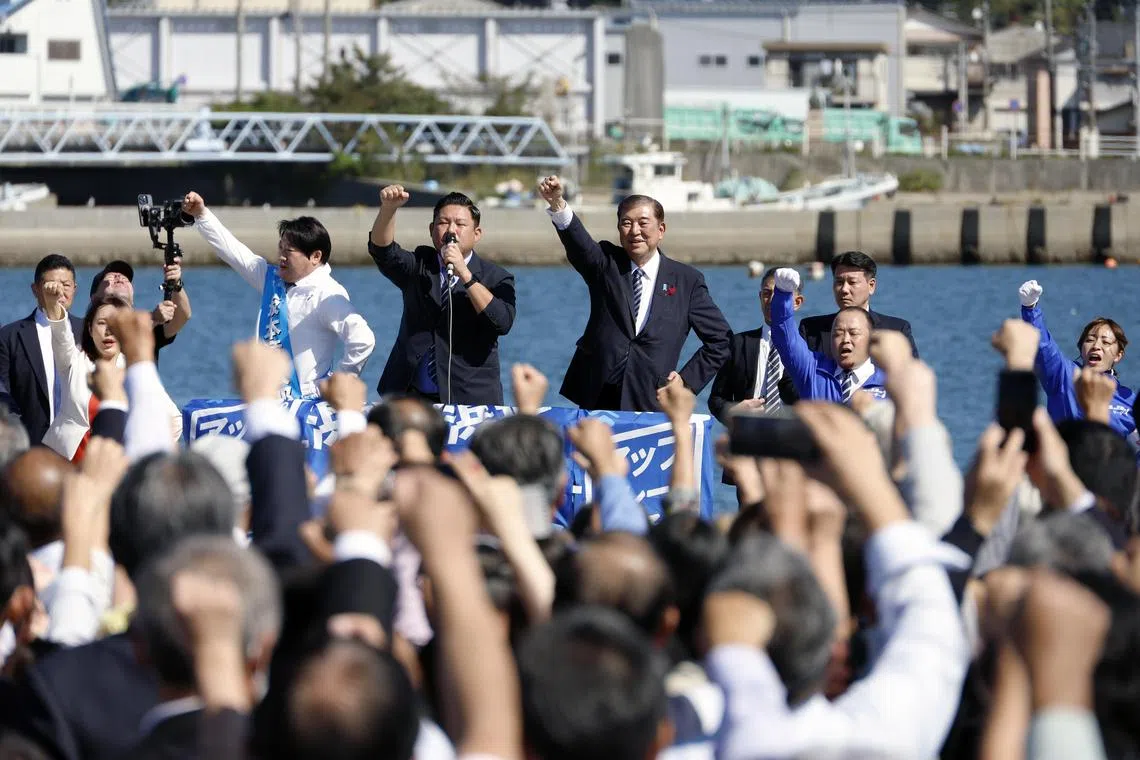 Japanese Prime Minister Shigeru Ishiba (C) raises his fist after delivering a stump speech for a ruling Liberal Democratic Party (LDP) candidate at an election campaign rally at Onahama Fish Market in Iwaki, Fukushima on Oct 15.
