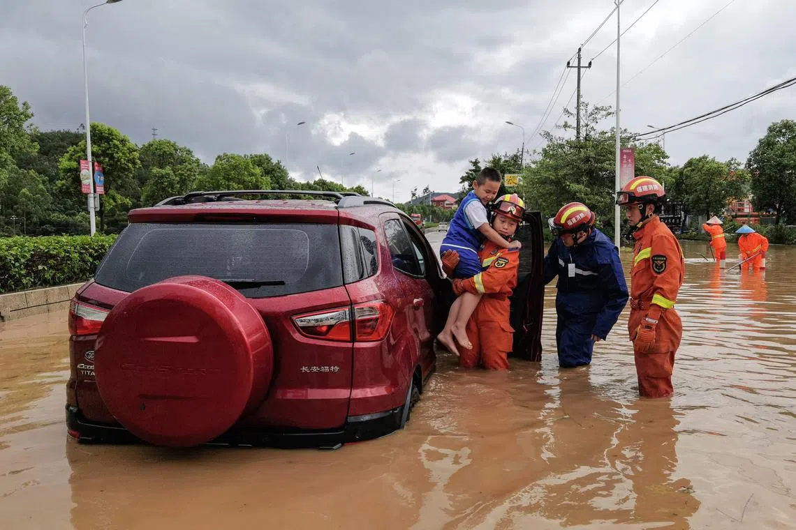 TOPSHOT - Rescuers evacuate residents in a flooded area after Typhoon Doksuri landfall in Quanzhou, in China's eastern Fujian province on July 28, 2023. (Photo by CNS / AFP) / China OUT