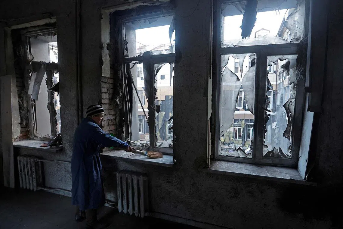 A woman removes broken glass inside a hospital damaged by recent shelling in the course of Russia-Ukraine conflict in Donetsk, Russian-controlled Ukraine, Dec 20, 2022. 