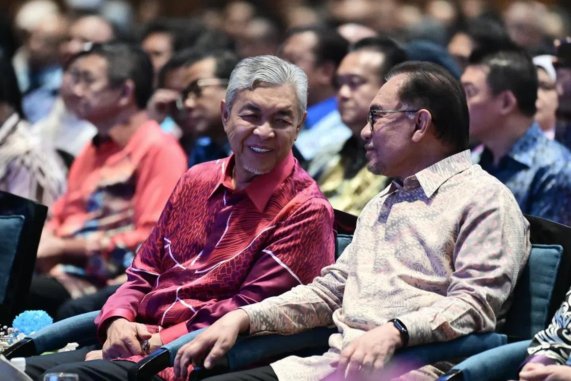 Malaysia DPM Zahid Hamidi (in red) with PM Anwar Ibrahim (right) at an event to launch Mr Anwar's new Malaysia Madani slogan.