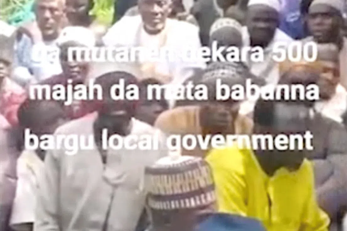 People sit on the grass in this screen grab obtained from a social media video released by an armed group on August 23, 2026, showing what residets said were about 600 women, children and older people abducted in an attack on a mosque in Nigeria’s north-central Niger State. SOCIAL MEDIA/via REUTERS