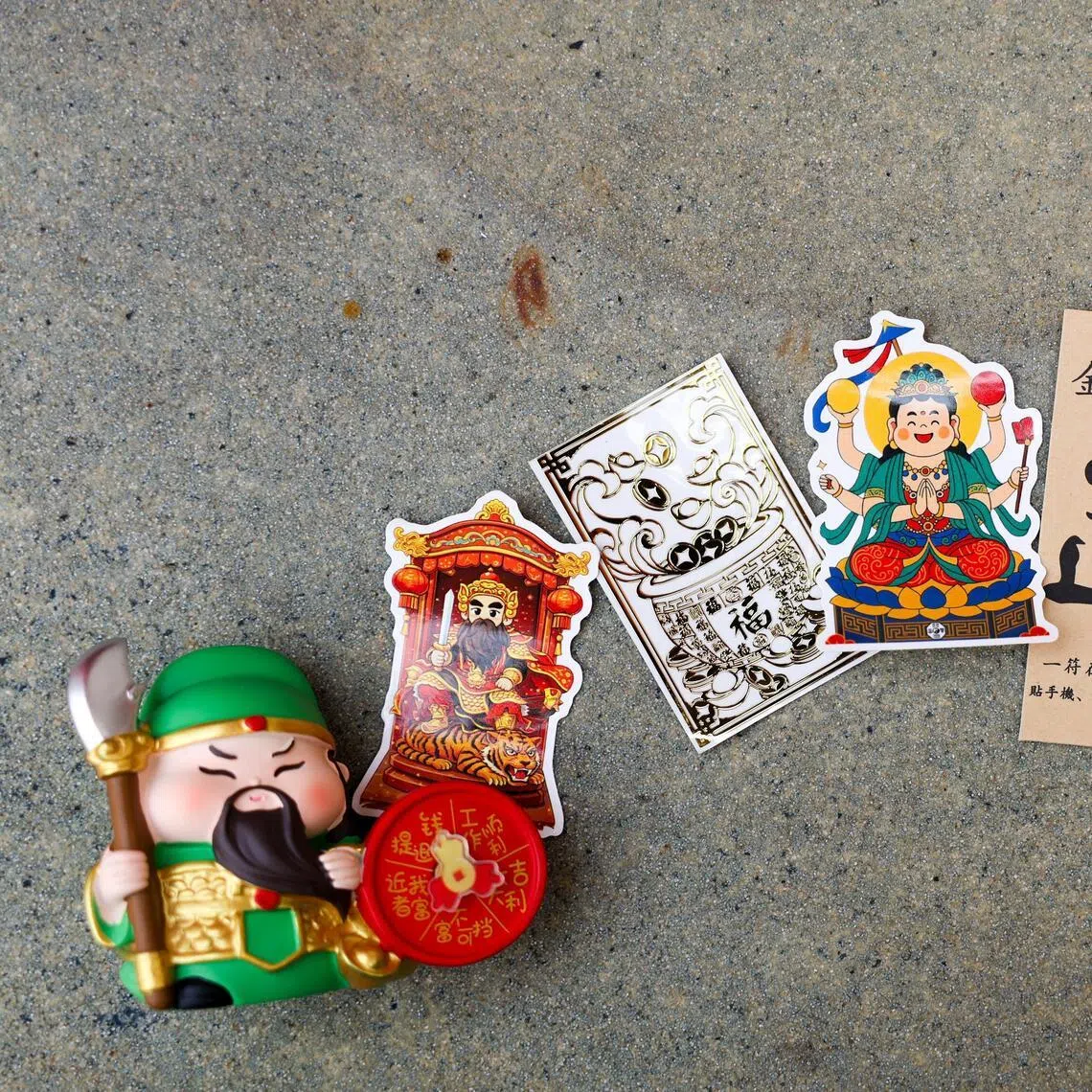 Prizes the “blessings” blind boxes include (from left) a Guan Gong desk buddy, deity stickers, a phone amulet, Patriarch Lu's wisdom brush and a Guanyin figurine.