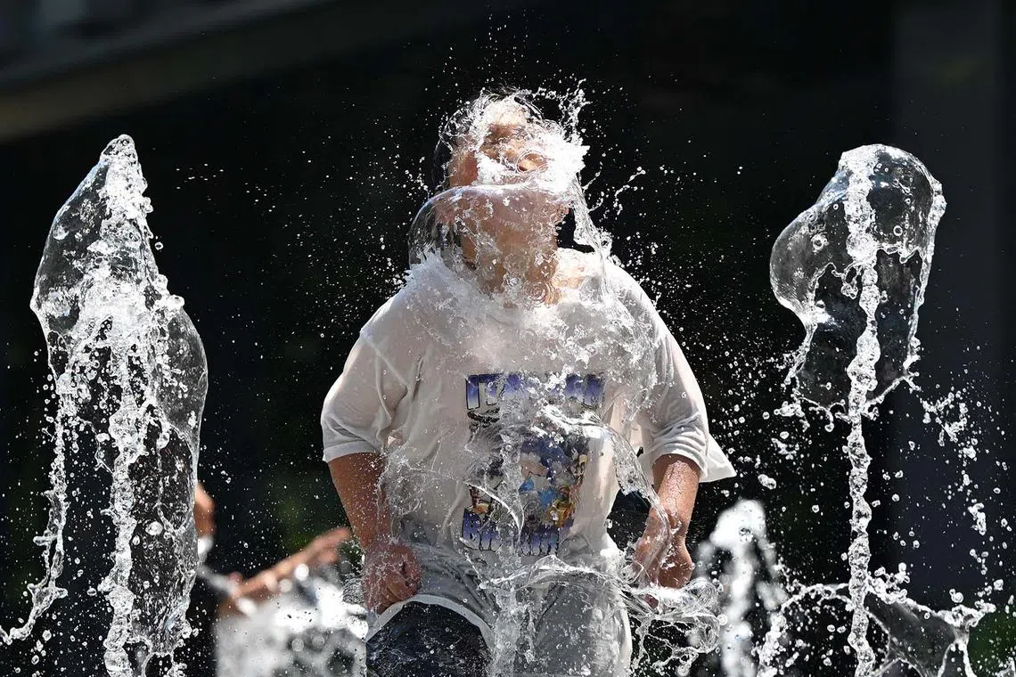 A child playing in a fountain to cool off in the central Gwanghwamun area of Seoul on July 10, 2025, as a heat wave warning has been issued by the South Korean government. 