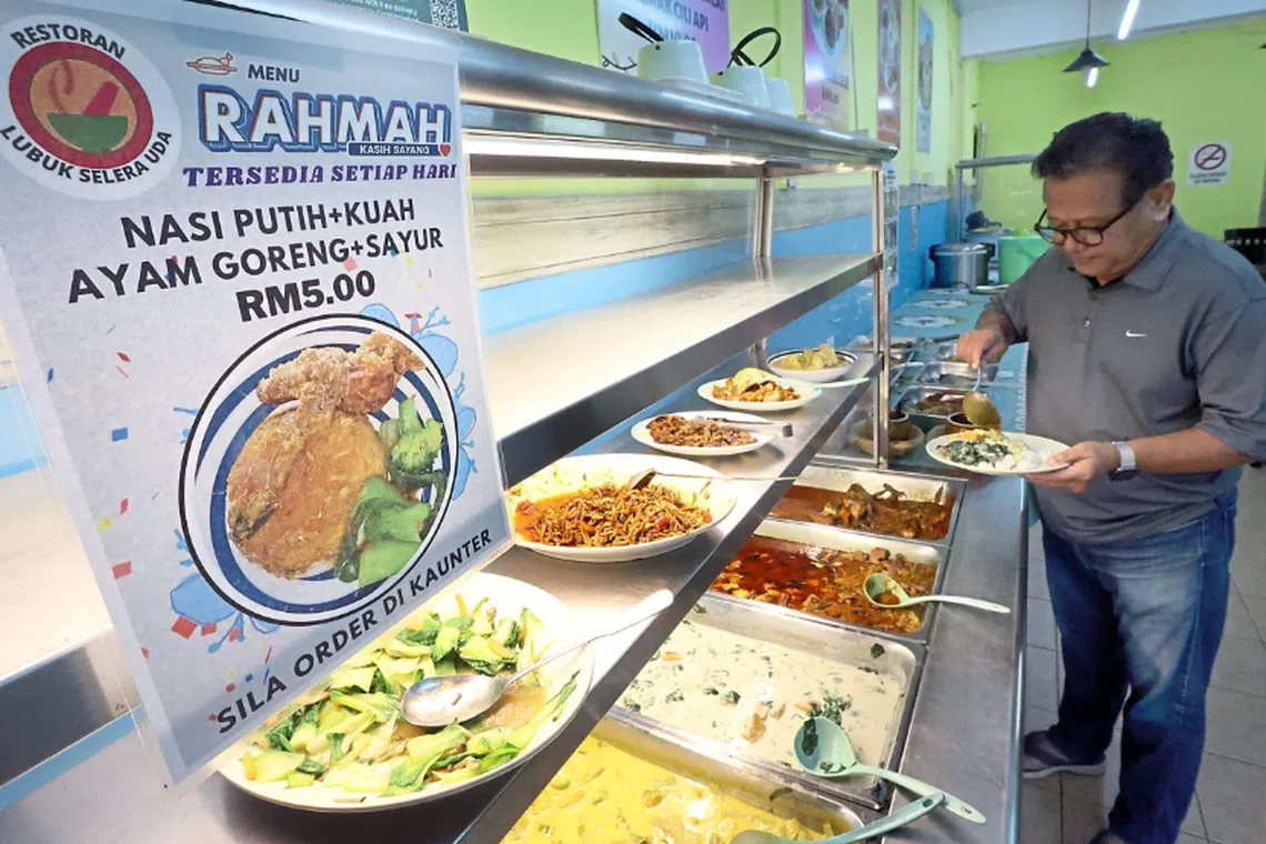 A customer seen choosing dishes from the Rahmah Menu at a restaurant in Johor. 