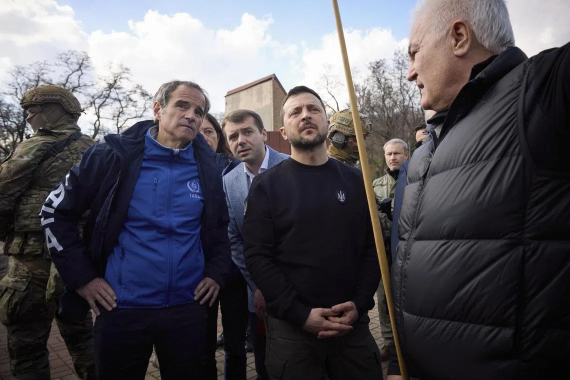 Ukrainian President Volodymyr Zelensky (centre) and International Atomic Energy Agency director-general Rafael Mariano Grossi (left) attend a meeting at the Dnieper Hydroelectric Station in Zaporizhzhia on Monday. 